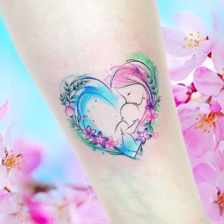 a small tattoo on the ankle of a girl with flowers and a heart shaped frame