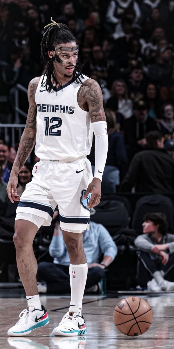 a basketball player with dreadlocks standing in front of a ball on the court