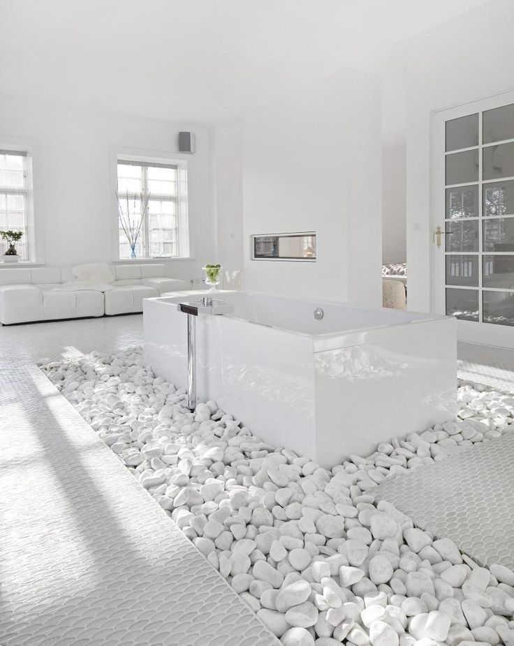 a white living room with rocks on the floor