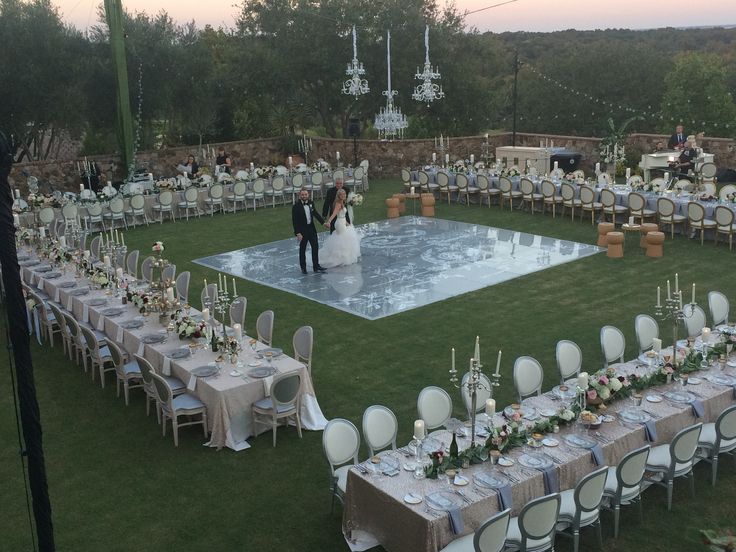 an outdoor wedding reception setup with tables and chairs set up on the lawn for guests