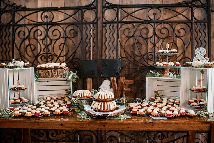 a table topped with lots of cakes and cupcakes