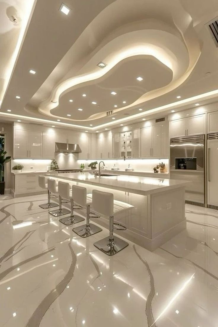 a large kitchen with marble floors and white cabinets is lit up by recessed lights