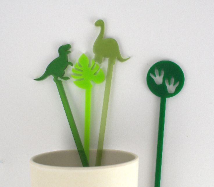 three paper flowers in a white vase with green stems and one is cut out to look like dinosaurs