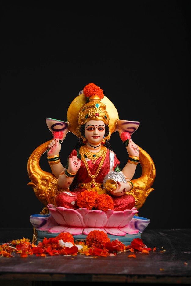 a statue of the god sitting on top of a flower arrangement