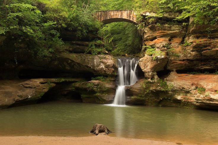 a waterfall with a bridge in the background