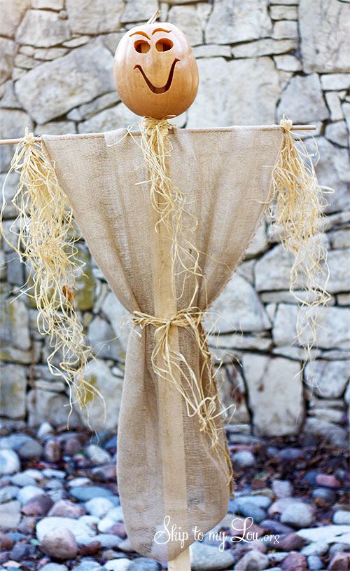 a scarecrow made out of burlock with a pumpkin on it's head