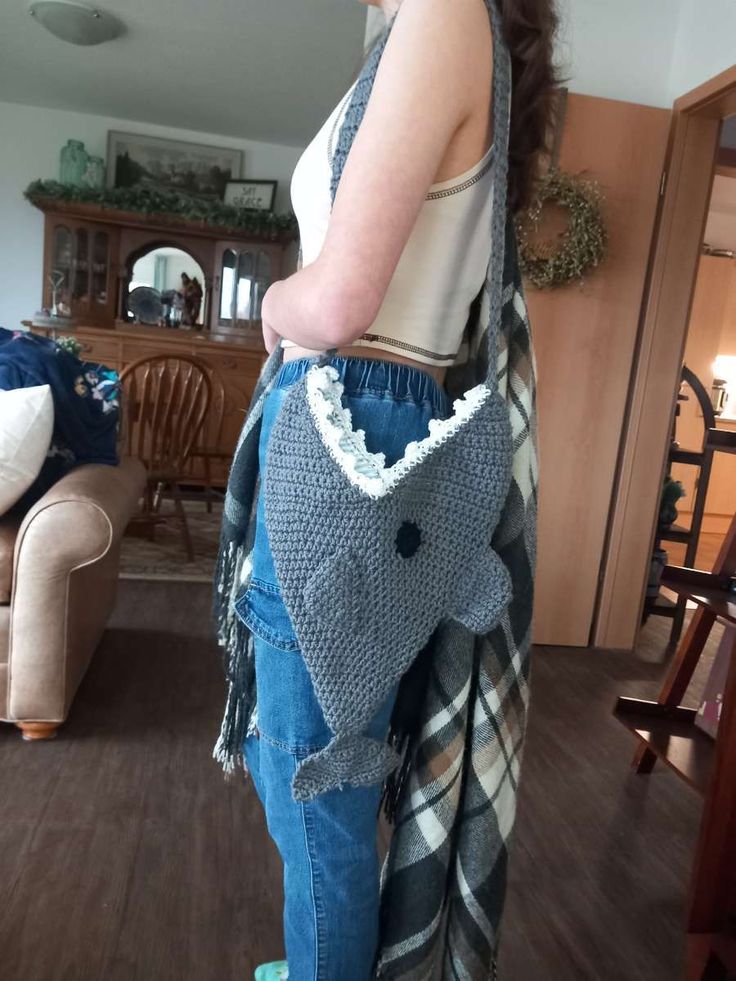 a woman is standing in the living room with her hand on her hip and holding onto an elephant purse