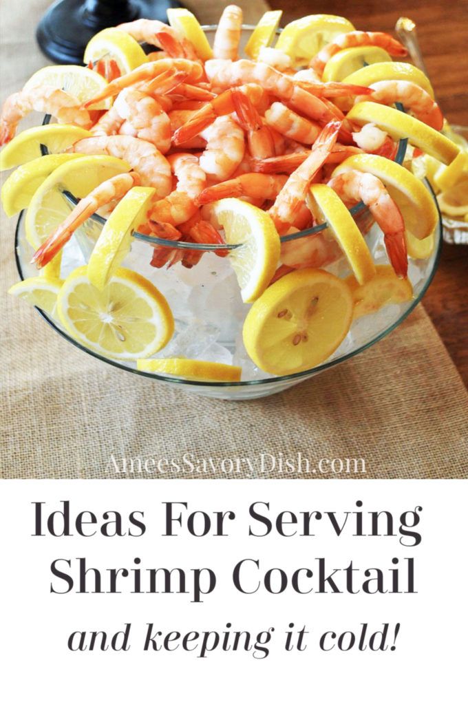 a glass bowl filled with shrimp and lemon slices