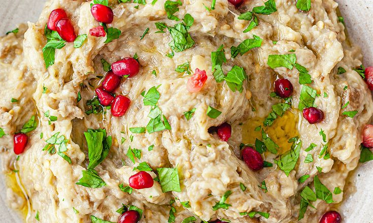 a white bowl filled with food and garnished with pomegranates