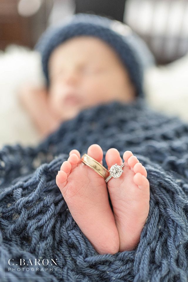 a baby's feet with a wedding ring on top of their toes in a blanket