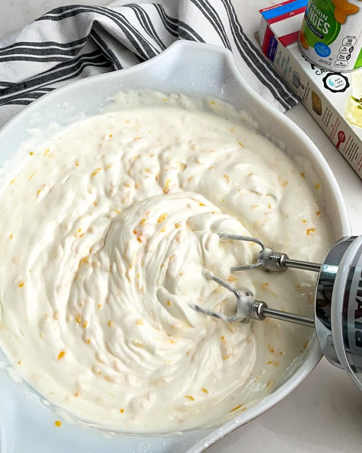 a white bowl filled with batter next to a box of milk