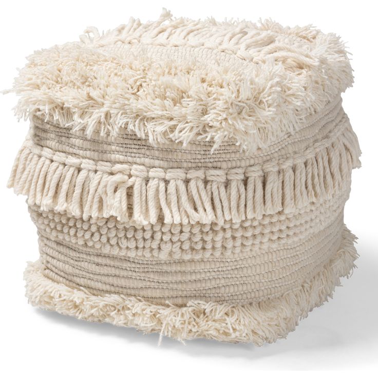 a large white basket with fringes on the top and bottom, sitting in front of a