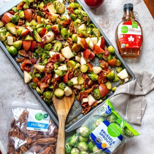 a pan filled with brussel sprouts, apples and bacon next to other ingredients