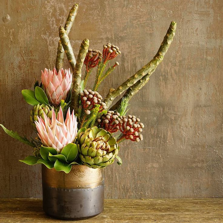 an arrangement of flowers in a vase on a table