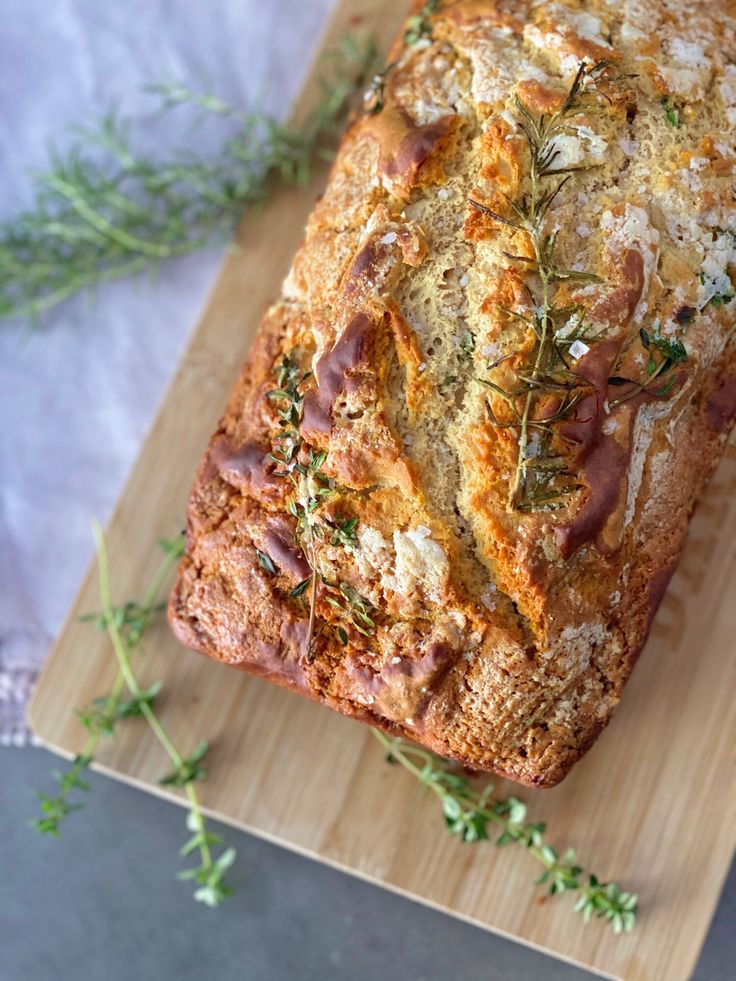 a loaf of bread sitting on top of a wooden cutting board