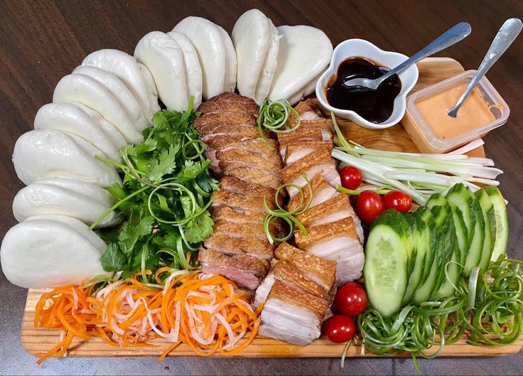 a platter filled with meat, vegetables and sauces