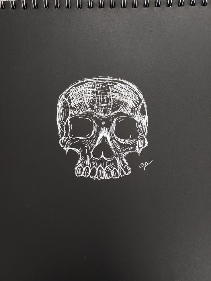 a drawing of a skull on a notebook