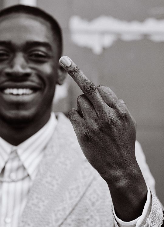 a black and white photo of a man pointing to the right with his finger in front of him