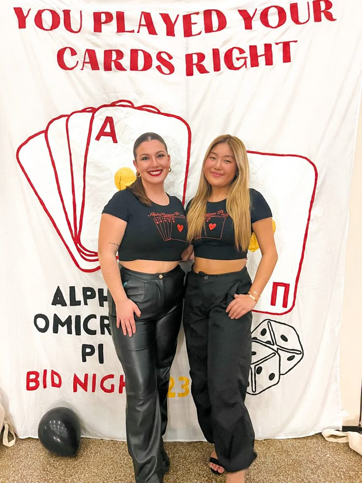 two women standing next to each other in front of a sign that says you played your cards right