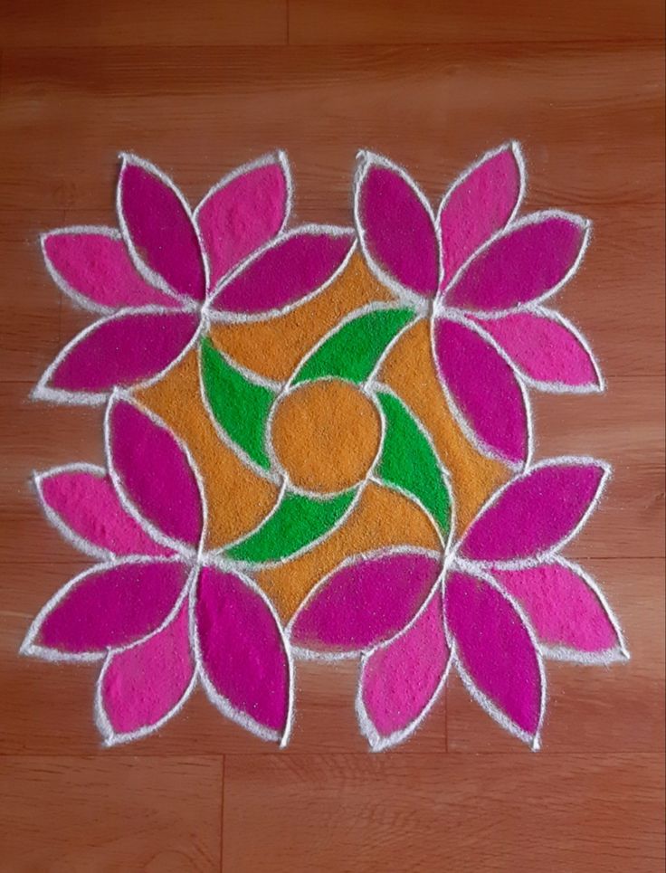 a colorful flower design is on the floor in front of a wooden floor with white and pink colors