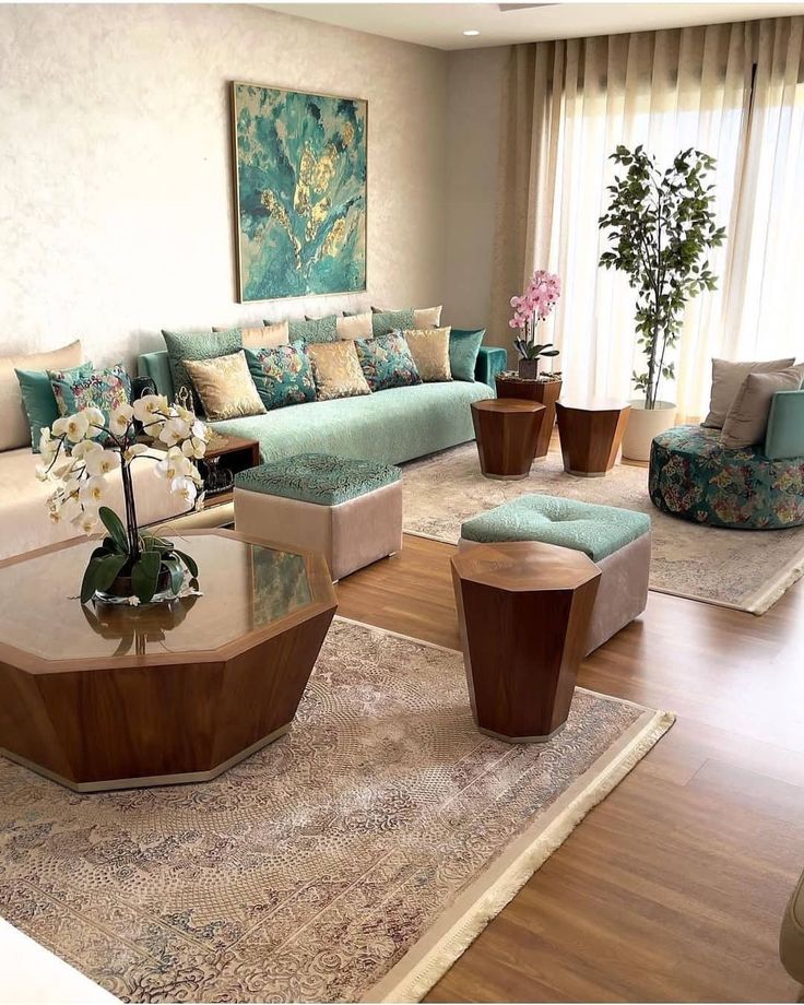 a living room filled with lots of furniture and flowers on top of a table in front of a window