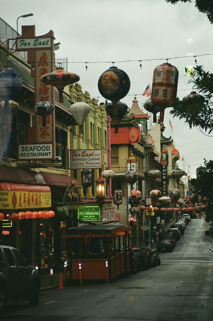 a city street lined with shops and parked cars