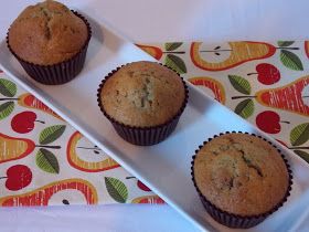 three muffins on a plate next to a cucumber