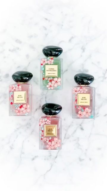 four bottles of perfume sitting on top of a marble counter