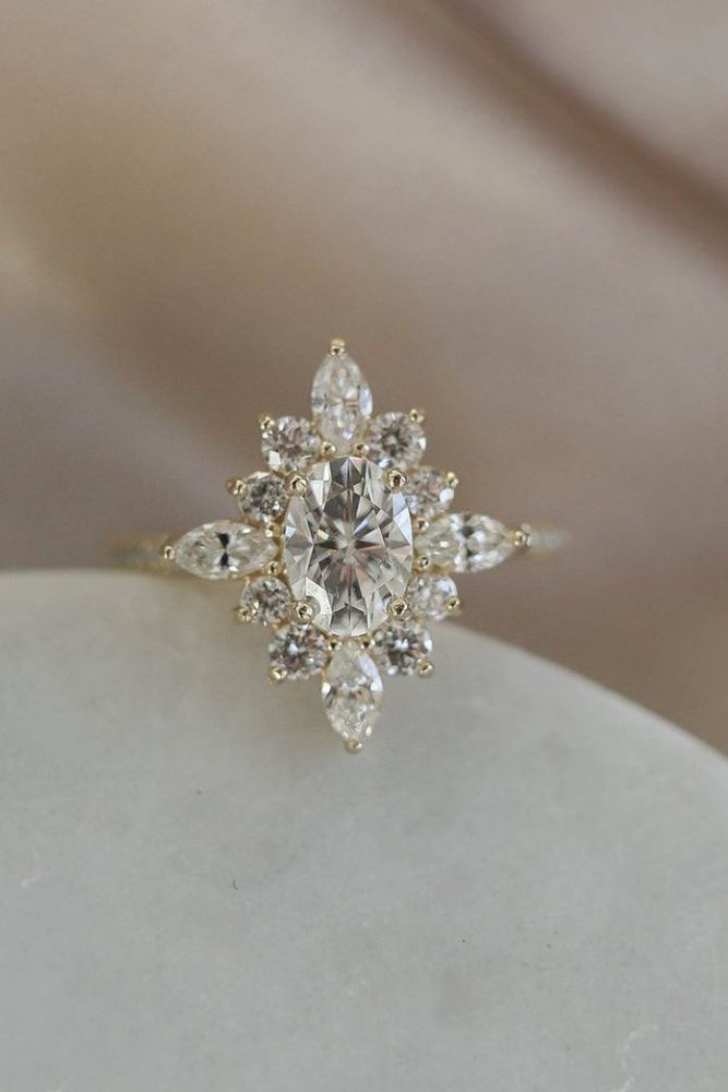 a diamond ring sitting on top of a white stone slab with some diamonds around it