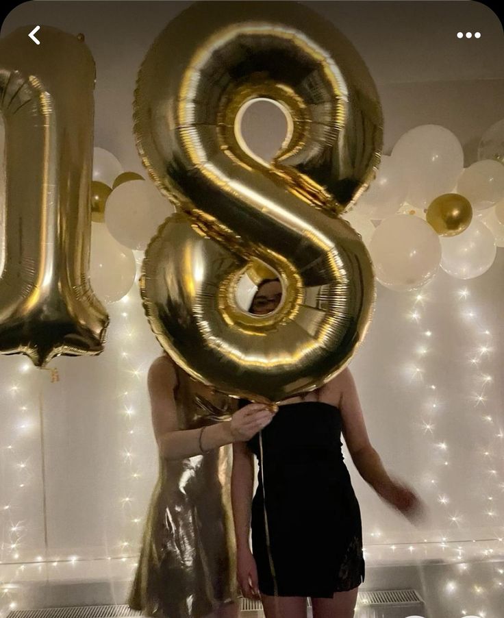 a woman standing in front of balloons with the letter s on it