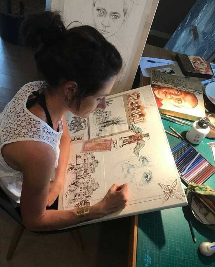 a woman sitting in front of a drawing board