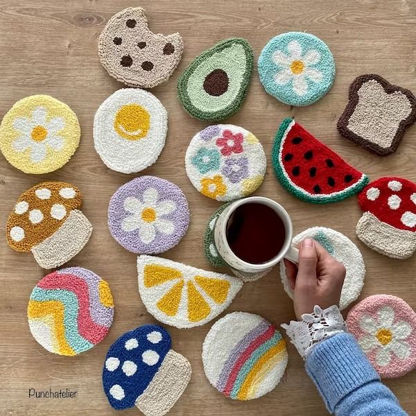 a person is holding a cup in front of some crocheted coasters