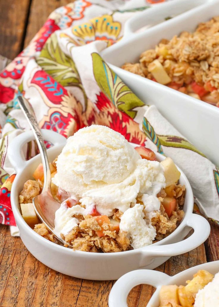 two bowls filled with fruit and ice cream on top of a wooden table next to another bowl