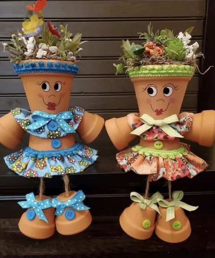 two clay pots with plants in them sitting on a table