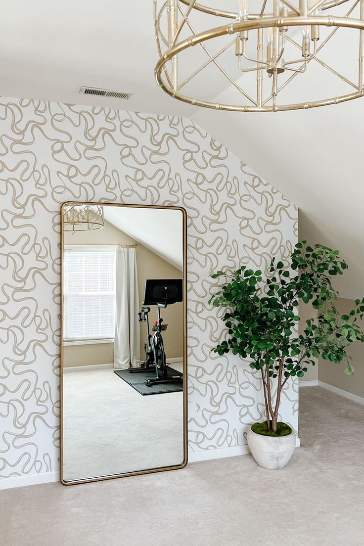 a large mirror sitting next to a potted plant on top of a white floor