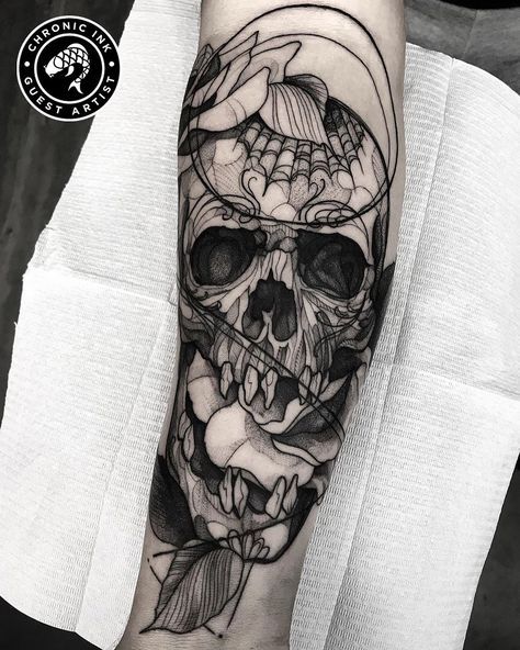 a man's arm with a skull and flowers on it