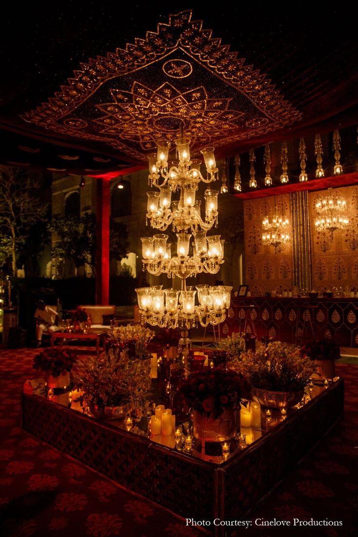 a chandelier hanging from the ceiling in a room with red walls and carpet