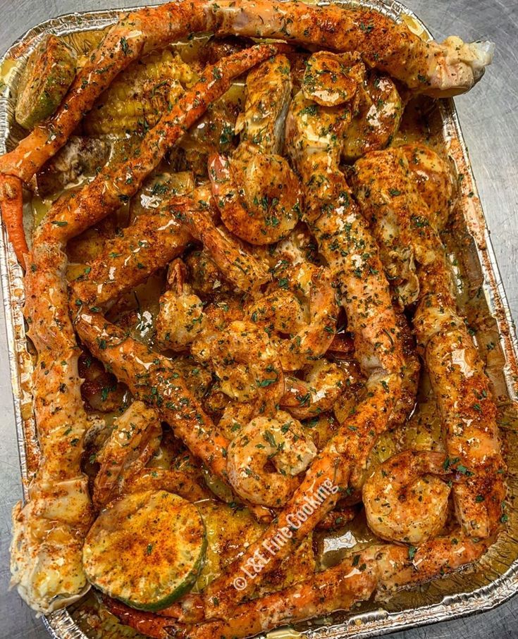 a tray filled with shrimp and vegetables covered in sauce