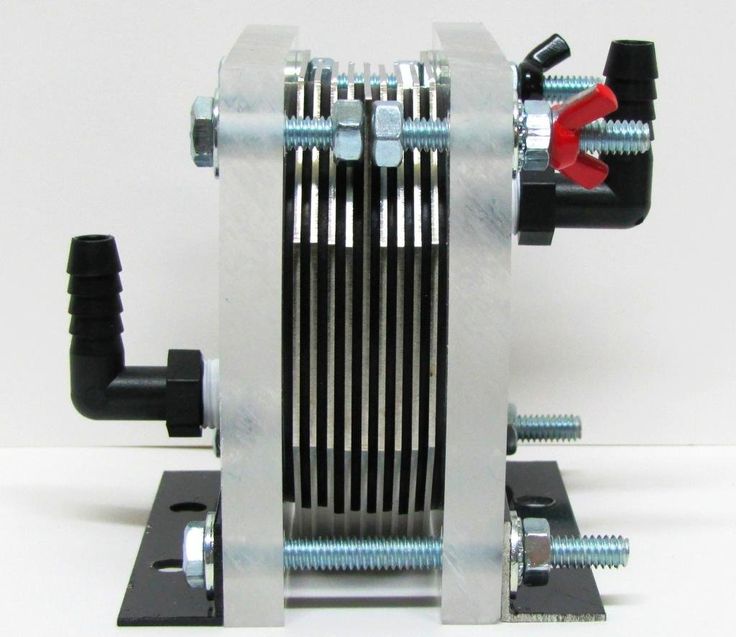 a machine that is sitting on top of a white surface with screws and nuts