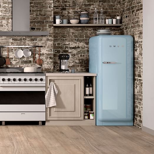 a kitchen with an old fashioned refrigerator, stove and oven in it's center