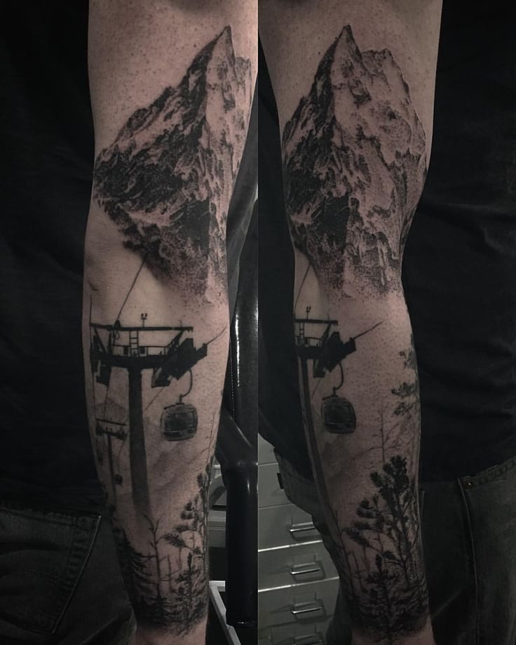 a man's arm with a mountain and ski lift tattoo on it