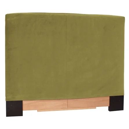 a bed with a green cover on top of it and wooden legs in front of the headboard