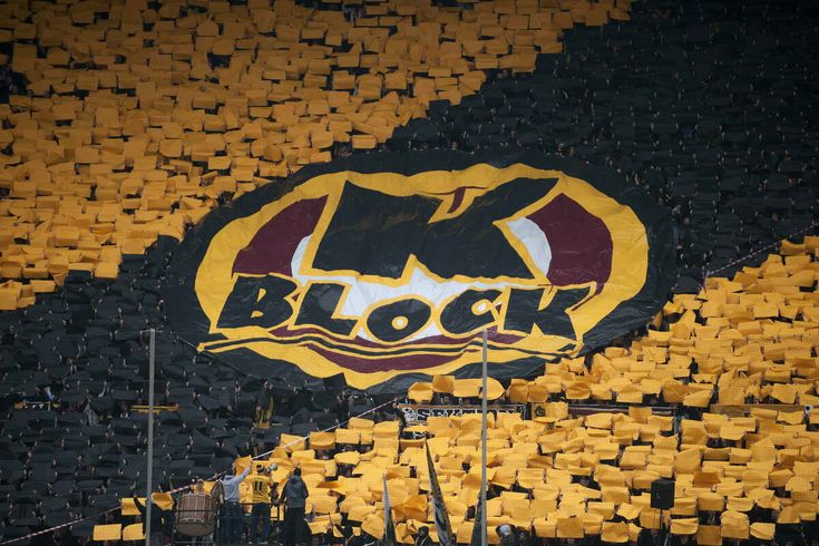 a black and yellow wall with the word block painted on it in front of an empty stadium