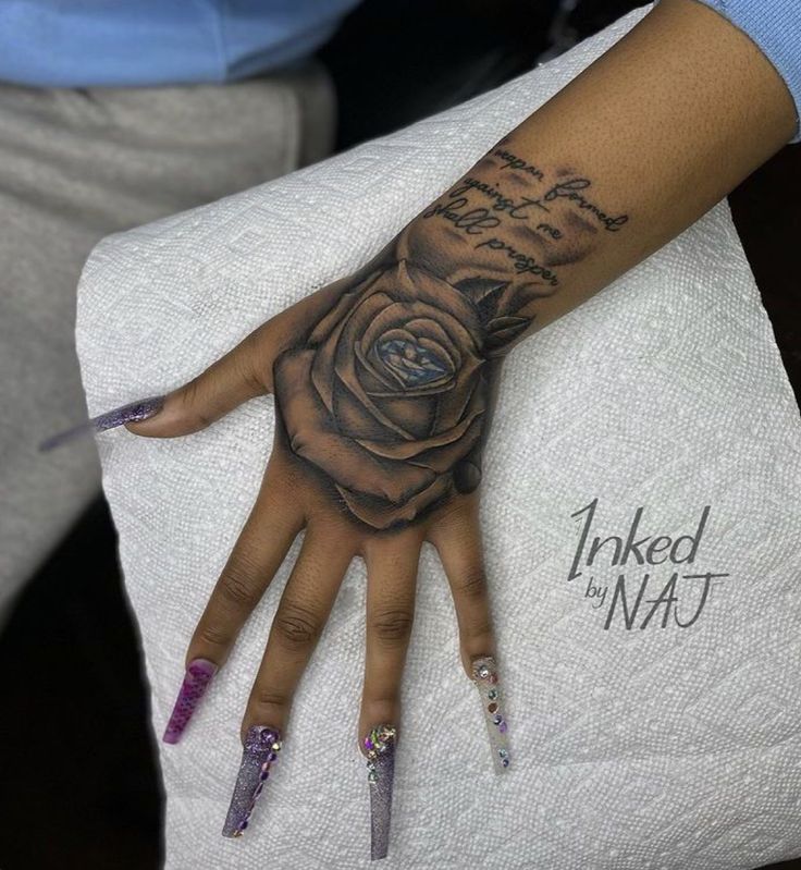 a woman's hand with a rose tattooed on the middle of her left arm