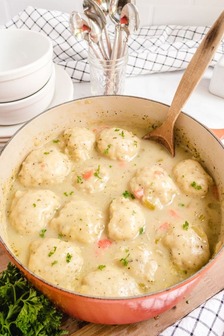 a pot filled with meatballs covered in gravy and garnished with parsley