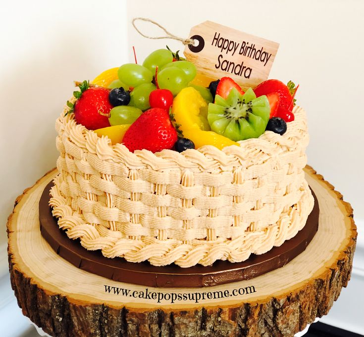 a birthday cake with fresh fruit on top