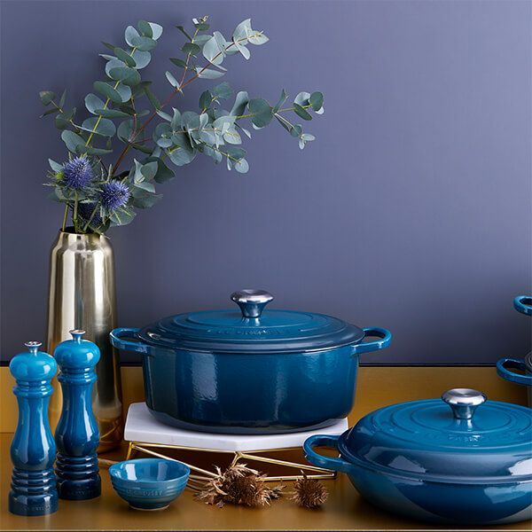 a table topped with blue pots and pans