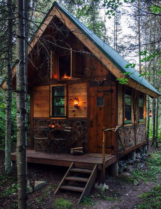 a small cabin in the woods with stairs leading up to it