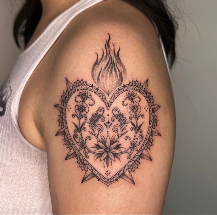 a woman's arm with a heart tattoo on the shoulder and flowers in the center