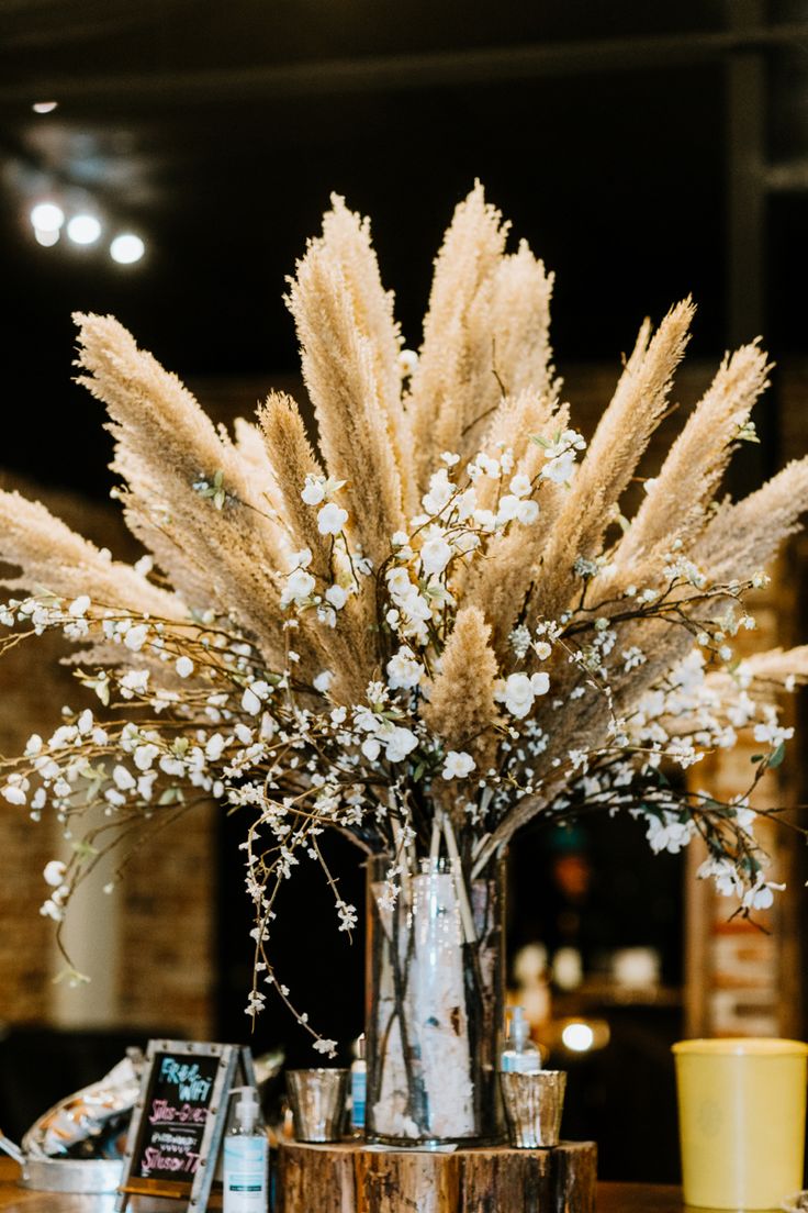 a vase filled with lots of flowers on top of a table